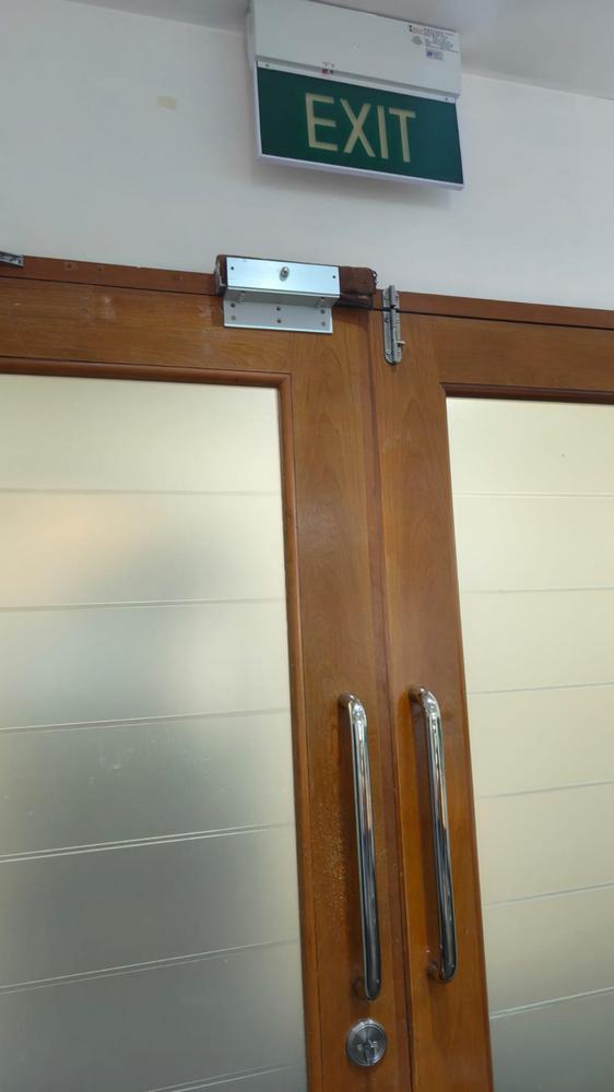 Magnetic door access system installed on double timber wooden office doors with emergency exit sign Singapore
